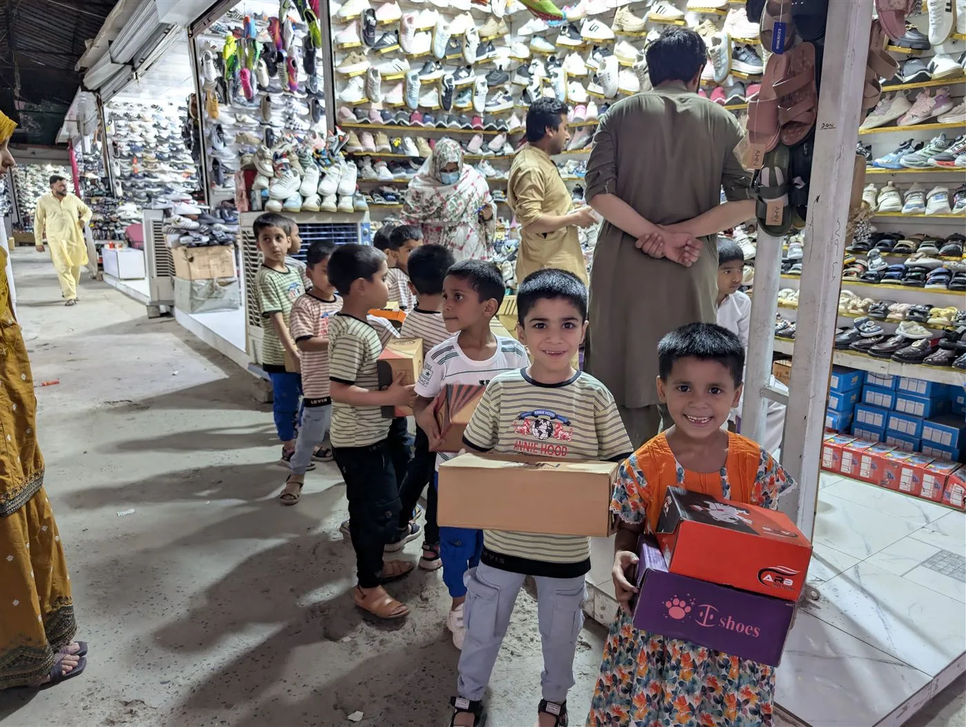 Children receiving new shoes during an Aasra outreach outing