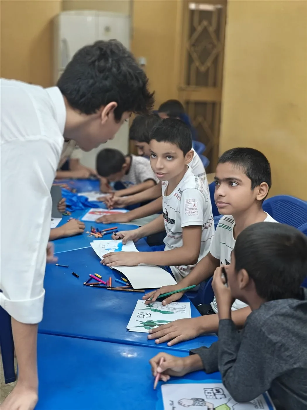 An Aasra volunteer mentoring children during an art session